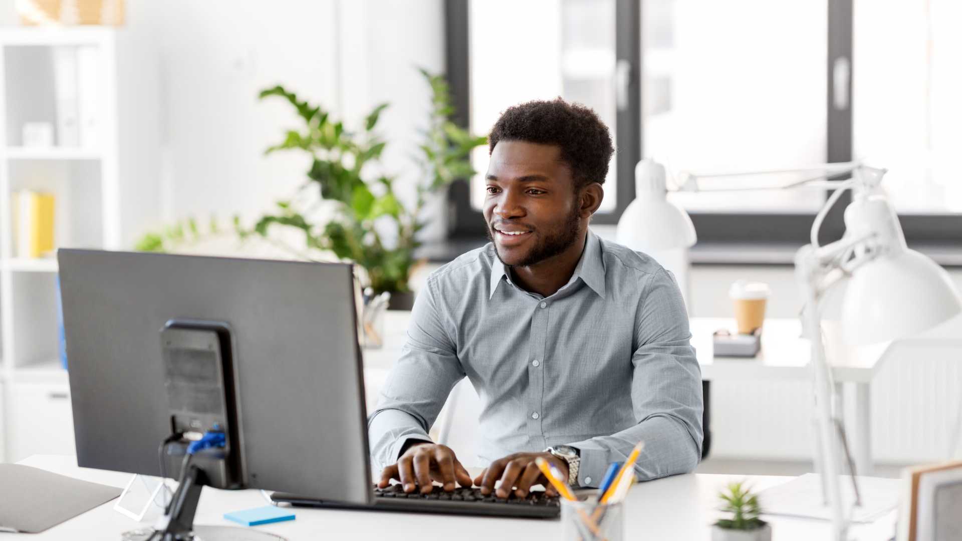 happy young businessman typing on computer