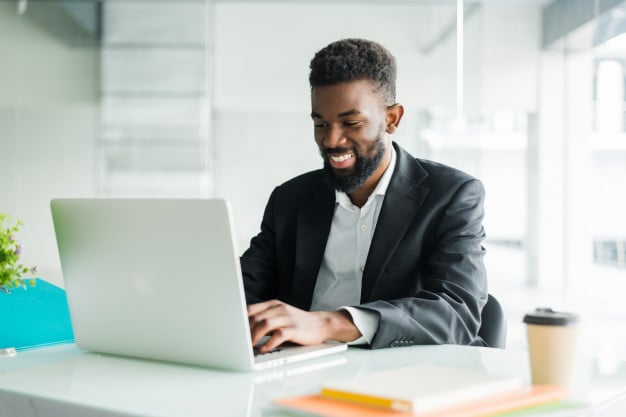 Thoughtful African American Businessman Using Laptop Pondering Project Business Strategy 